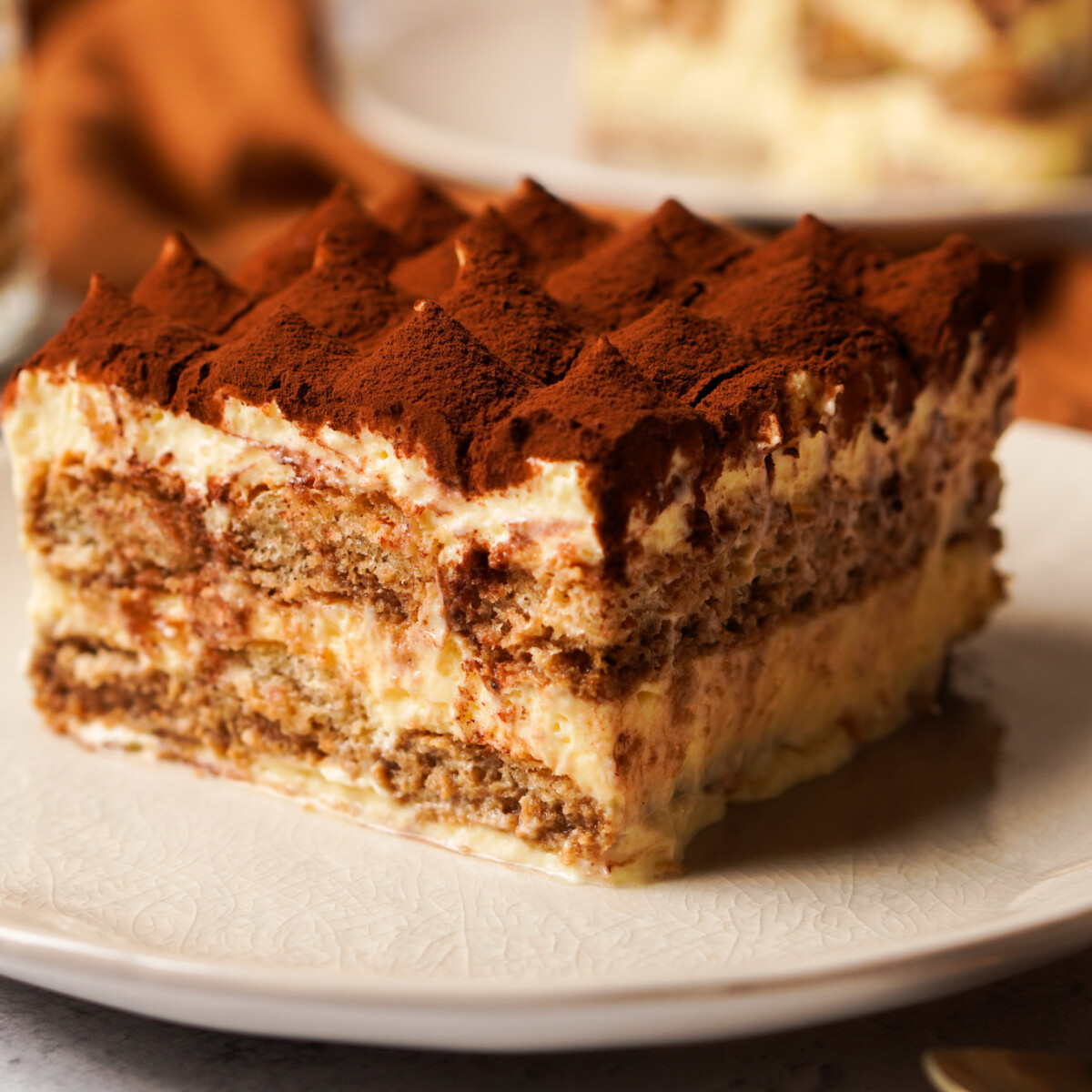 Klasszikus tiramisu tányéron, kakaóporral meghintve