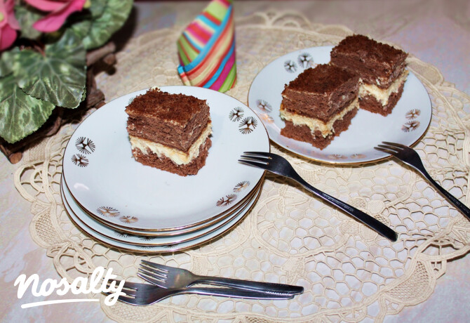 Mogyoróvajas-mascarponés krémmel töltött kakaós süteményszeletek tányérokon, villákkal tálalva.