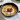 Serpenyőben tálalt, szeletekre vágott ropogós socca fetakrémmel, sült koktélparadicsommal és frissen őrölt borssal.