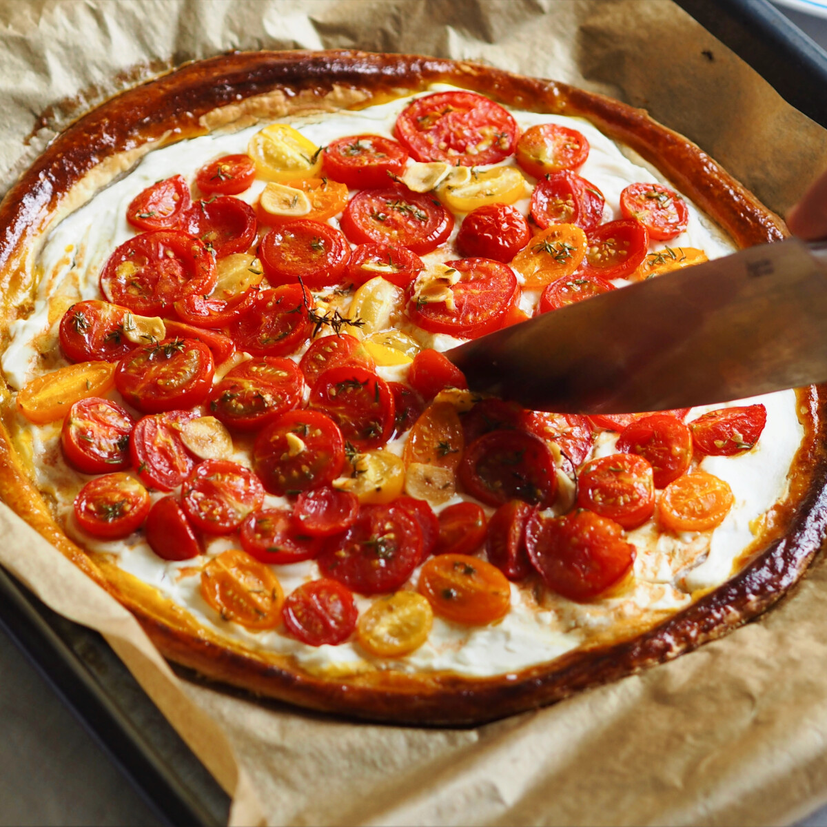 Paradicsomos tart leveles tésztából ricottás alappal, friss koktélparadicsommal, sütőpapíron, késsel szeletelve