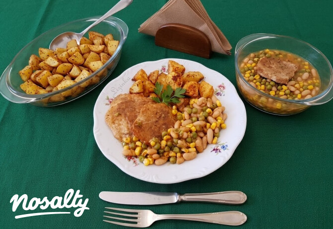 Babos-zöldséges sertéskaraj sült burgonyával tálalva, tányéron, petrezselyemmel díszítve.
