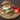 Szezámmagos hamburgerzsemlében tálalt reggelizőburger tükörtojással, ropogós baconnel, salátával és friss rozmaringgal, mellette egész és félbevágott paradicsom egy fa tálcán