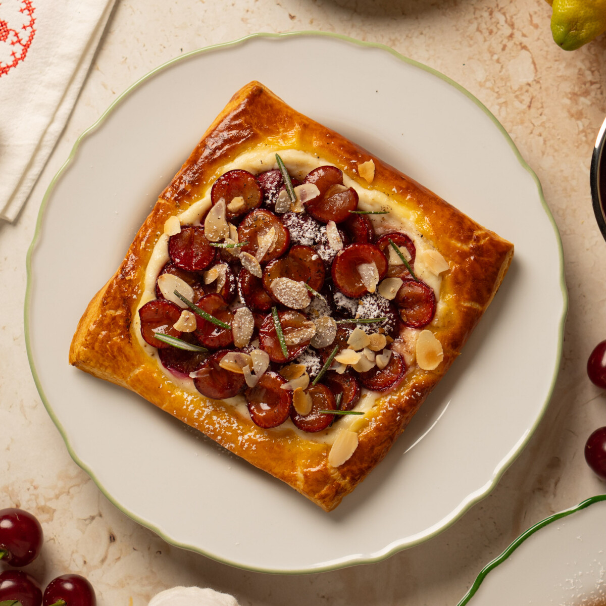 Leveles tésztából készült meggyes pite ricottakrémmel, a teteje porcukorral és mandulapehellyel megszórva